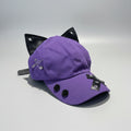 Purple cap with black cat ears and decorations on a wooden surface